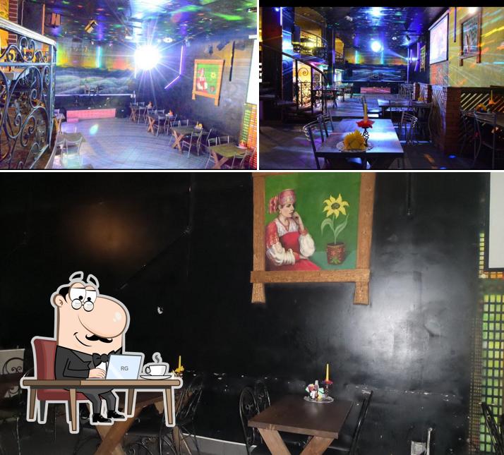 Изображение, на котором видны внутреннее оформление и столики в Ночь