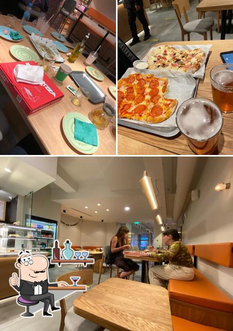 Снимок, на котором видны внутреннее оформление и столики в Zotman Pizza