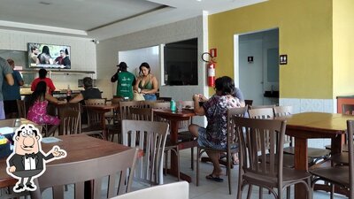 Sente em uma das mesas no Encontro do Sabor Restaurante & Pizzaria